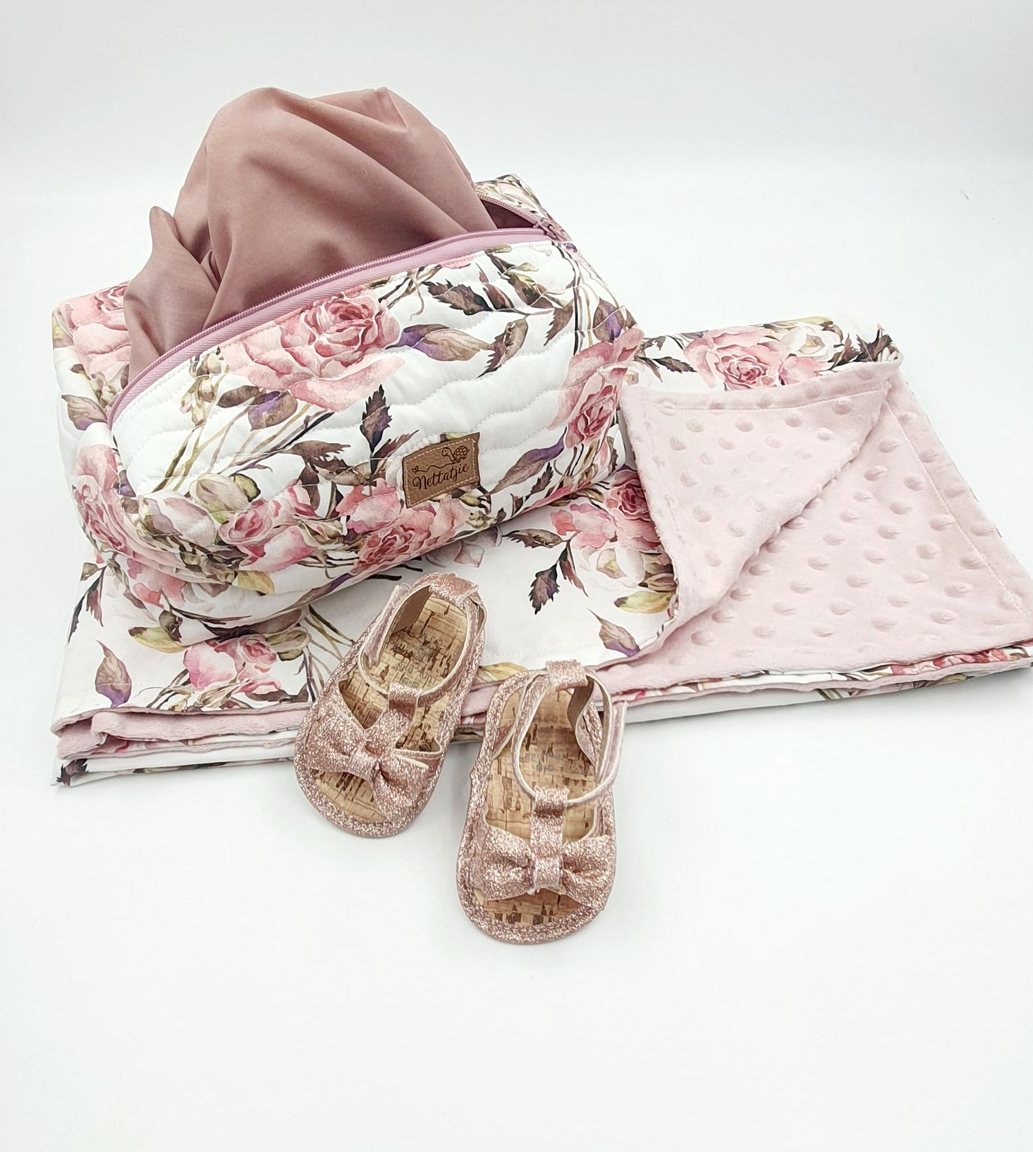 Baby accessories set with floral print bag, pink minky blanket, and rose gold sandals.