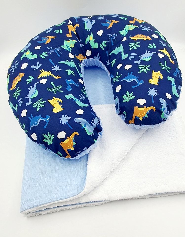 Navy blue nursing pillow with colorful dinosaur print pattern.