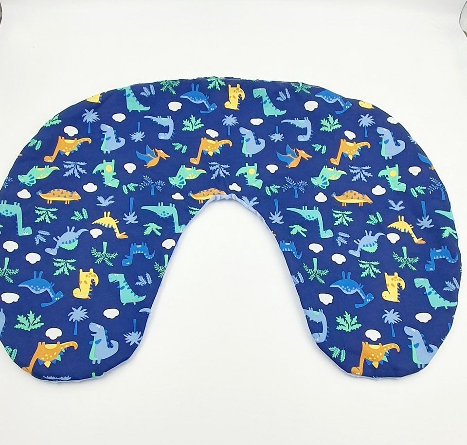 Dinosaur themed nursing pillow featuring playful prehistoric creatures on navy background.