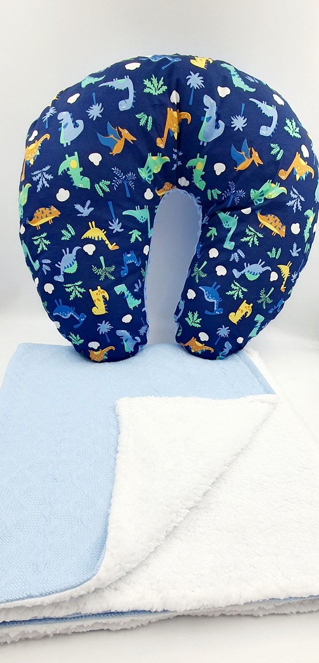Navy blue nursing pillow with playful sea creature pattern resting on light blue blanket.