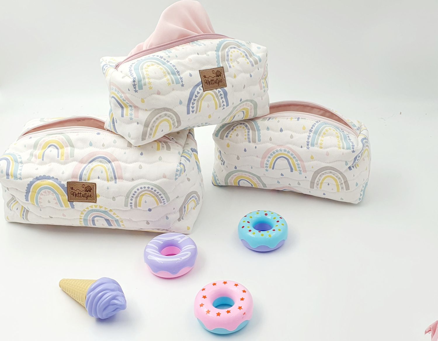 Baby wipes packages with rainbow design displayed with colorful donut teethers.