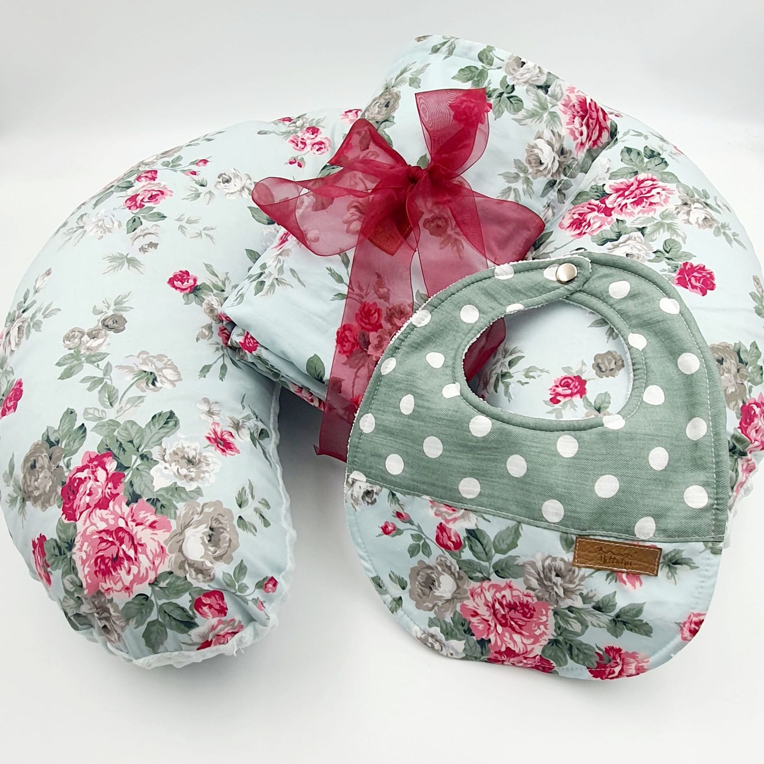 Vintage rose pattern nursing pillow with polka dots and red bow accent.