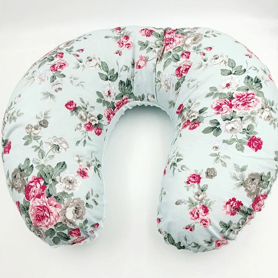 Floral print nursing pillow featuring pink roses on light mint background.