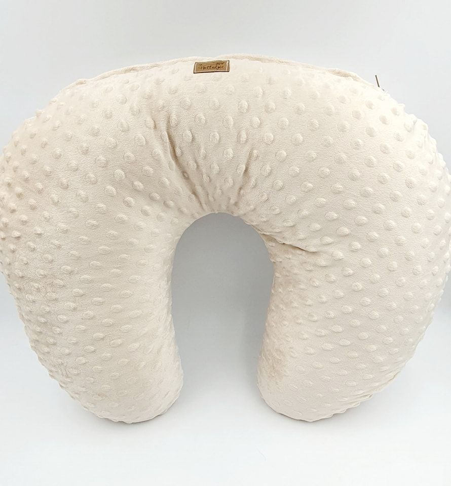 Cream colored minky nursing pillow with textured dot pattern.