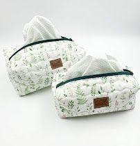 Mint green botanical print makeup bags with navy trim displayed in various positions.