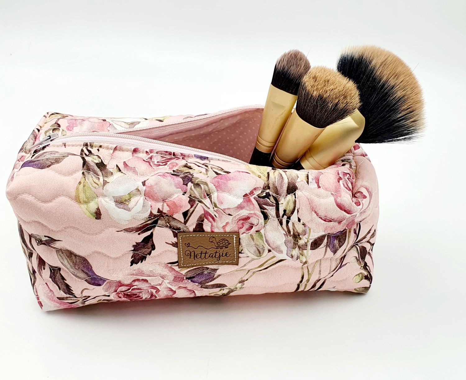 Pink floral pattern makeup brush case shown from different angles with brushes.