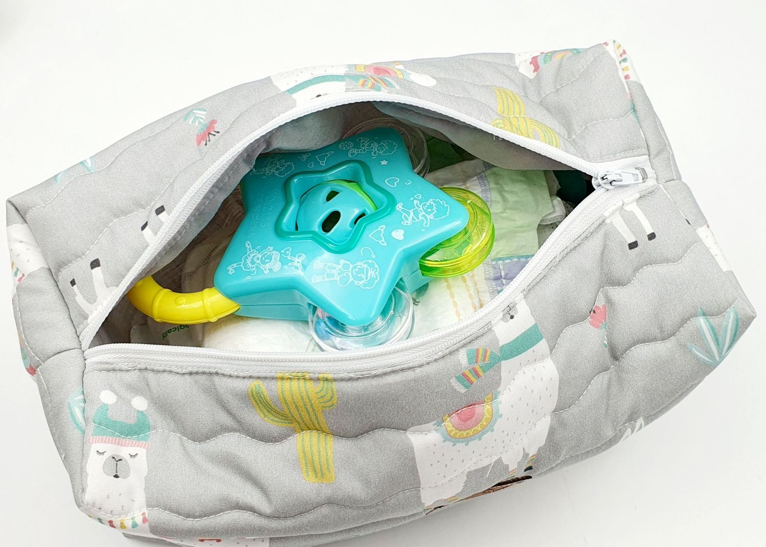 White diaper bag with rainbow pattern opened to show interior storage space.
