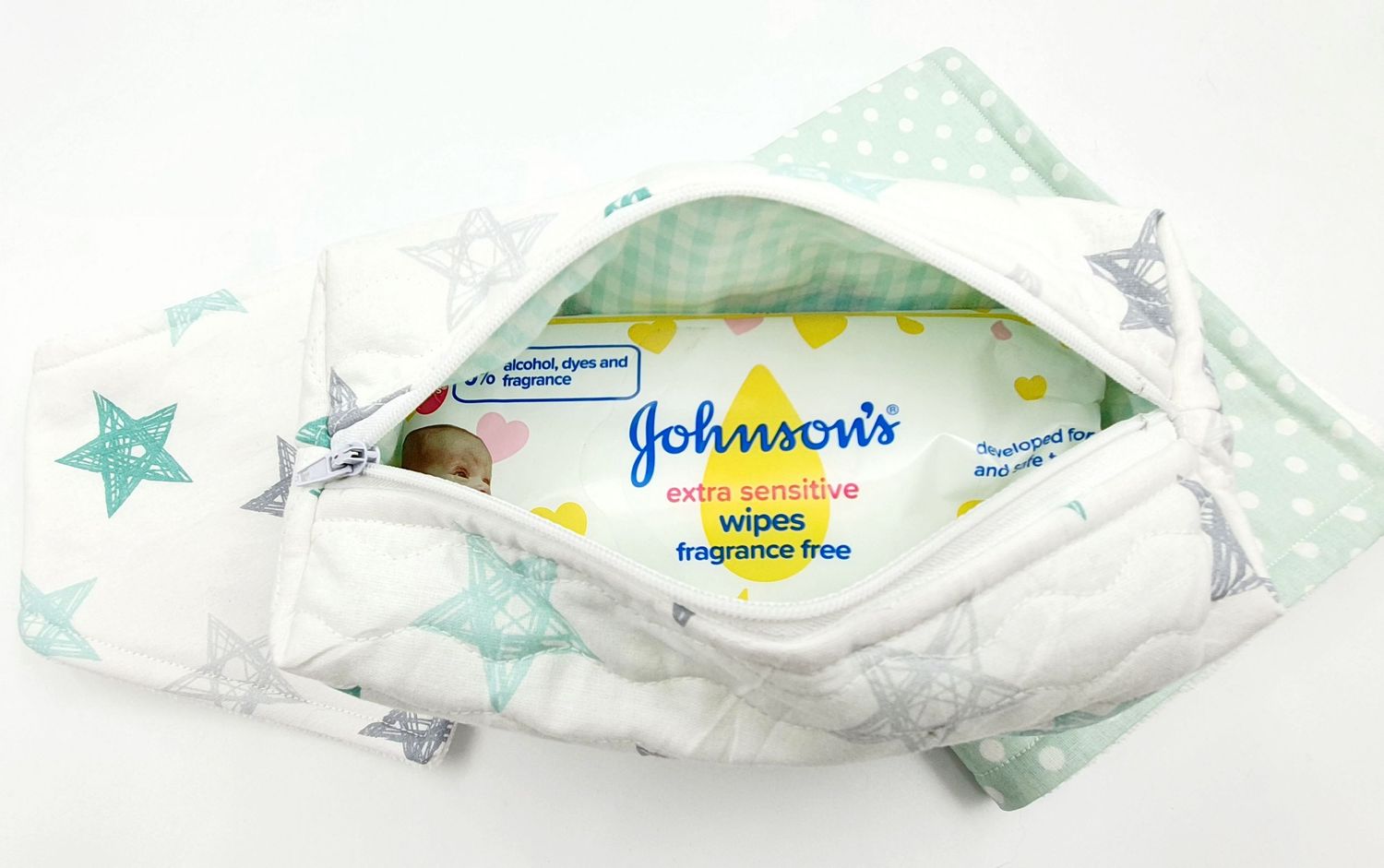 White and mint star-patterned fabric pouch containing Johnson's baby wipes package.