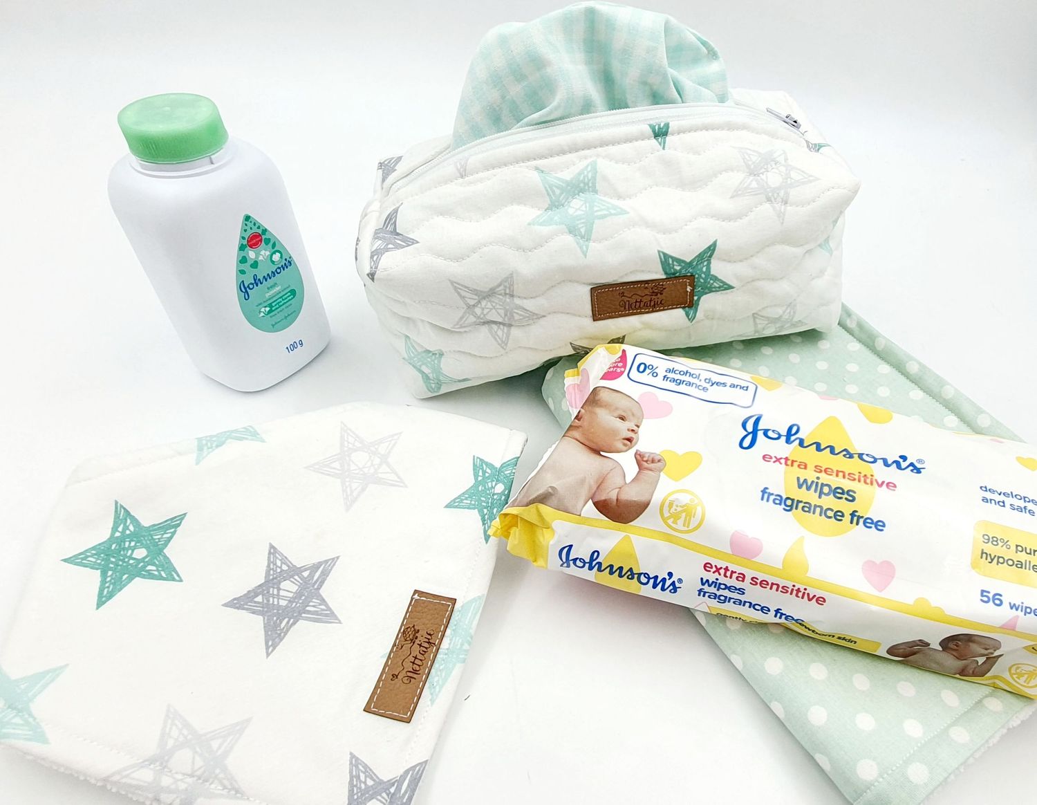 Baby care items including wipes, lotion and star-patterned storage pouch in mint green and white.