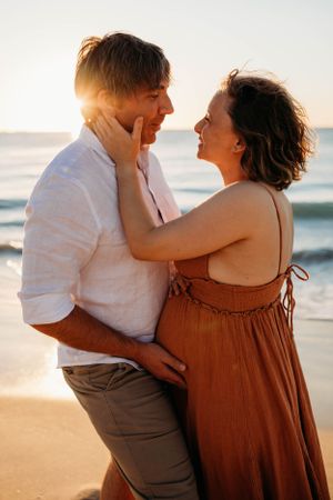 a couple embracing on the beach during a photoshoot with India Foxx photographer, a maternity photographer based in Shrewsbury.