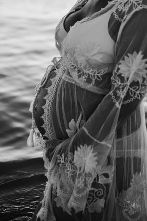 a pregnant mum to be having a maternity shoot stood in the water at golden hour by India Foxx Photography. a family photographer.