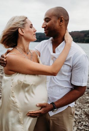 a happy couple outdoors in Shrewsbury at sunset celebrating becoming parents in maternity shoot - photo shot by India foxx photography.