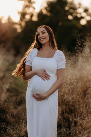 a pregnant mum to be posing during a natural outdoors autumn maternity photoshoot with India Foxx Photography