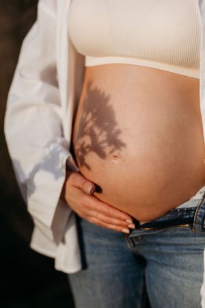 a pregnant mum to be posing during a natural outdoors autumn maternity photoshoot with India Foxx Photography