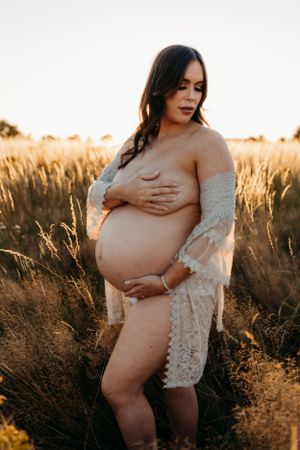 semi nude maternity photoshoot in full sun on a summers evening in a field in Shrewsbury shot by India Foxx Photography.