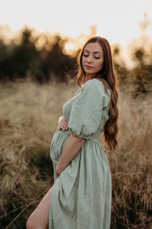 a pregnant mum to be posing during a natural outdoors autumn maternity photoshoot with India Foxx Photography