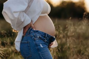 a pregnant mum to be posing during a natural outdoors autumn maternity photoshoot with India Foxx Photography