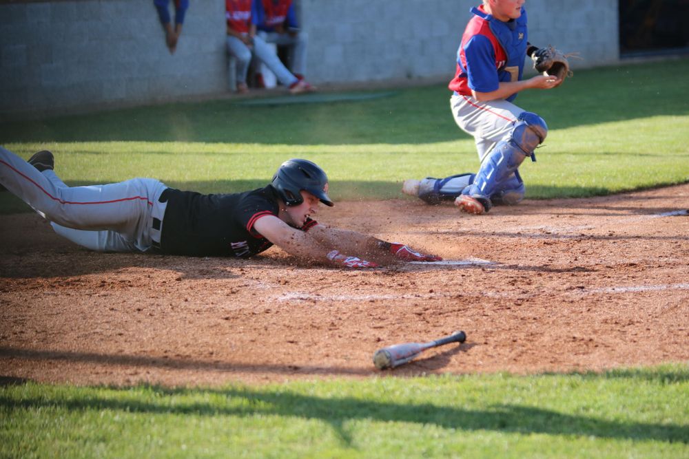 Baseball game action sequence showing player sliding into base with dirt flying.