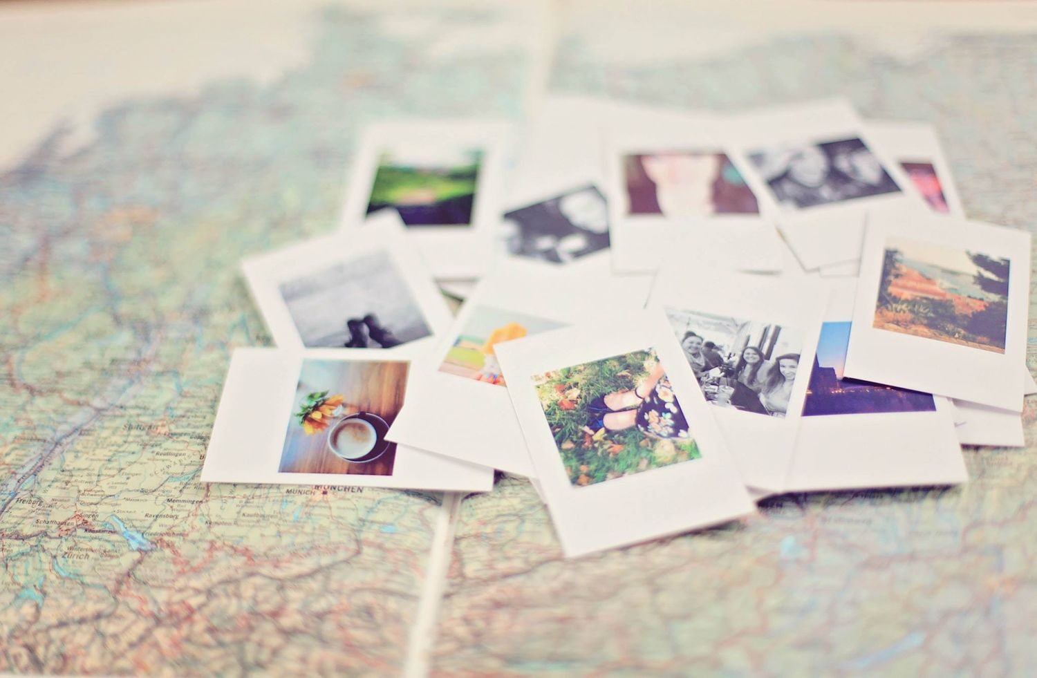 Polaroid photos scattered on a world map, suggesting travel memories and adventures.
