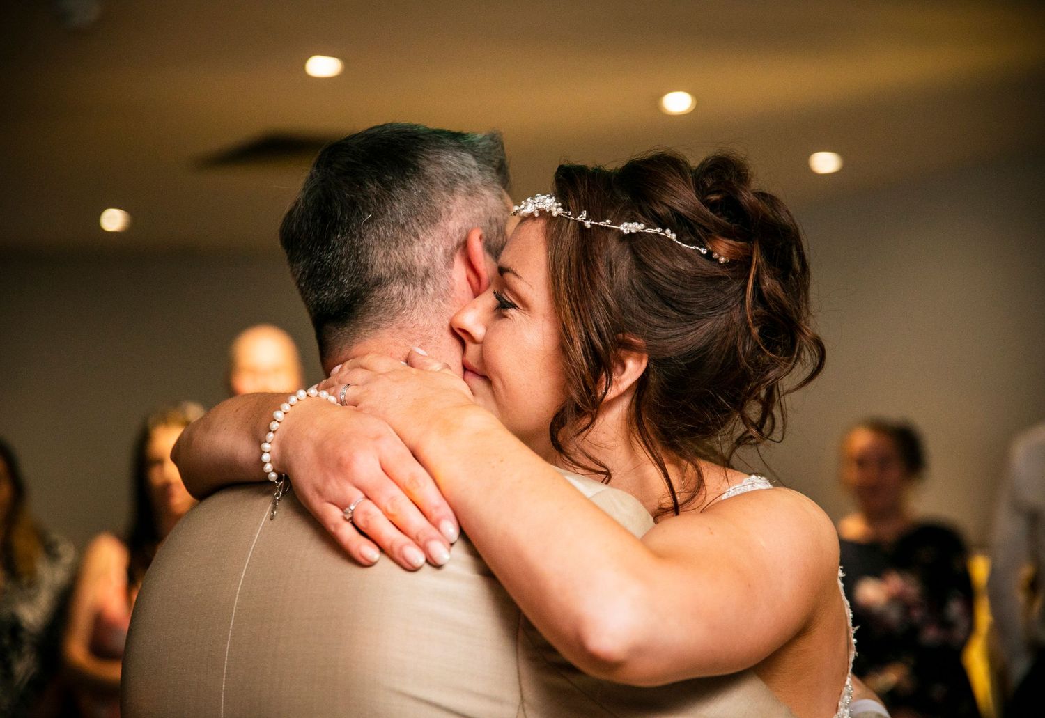 Intimate dance floor moments captured during a wedding reception with warm lighting.