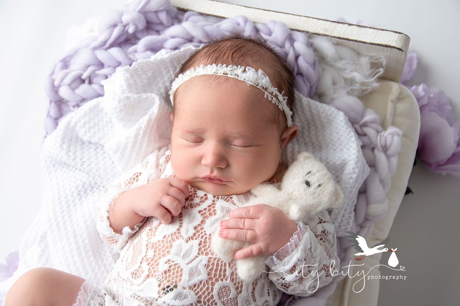 Baby Ellis holding a bear during her newborn photography session in Avon Ohio with Ity Bity Photography