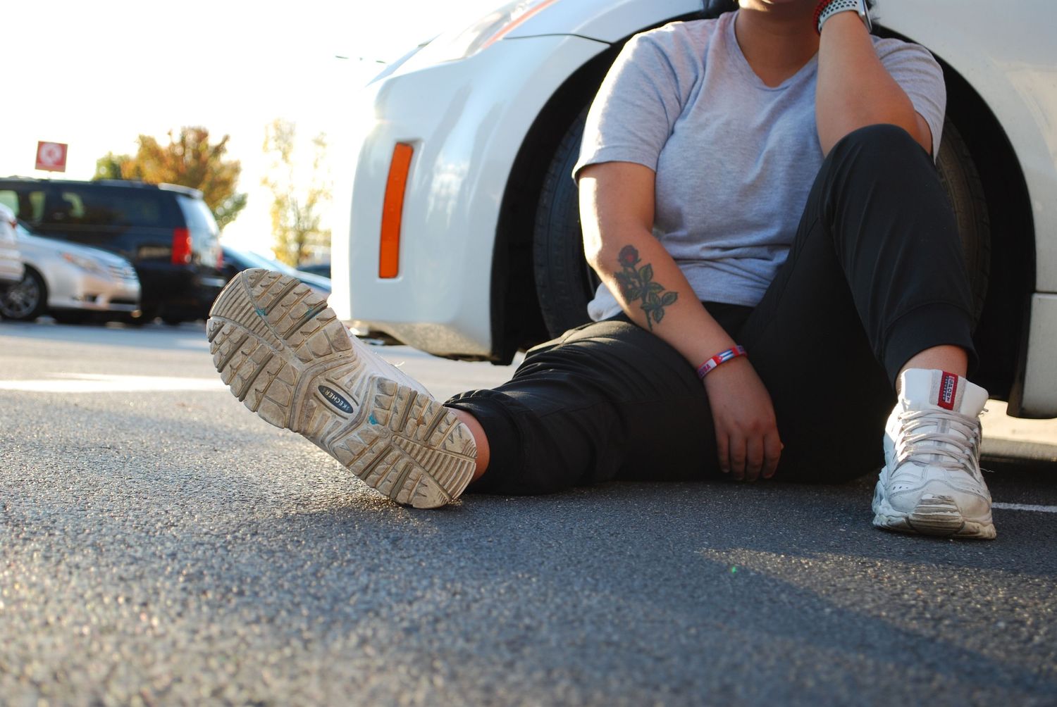 Shoes on someone sitting next to their car
