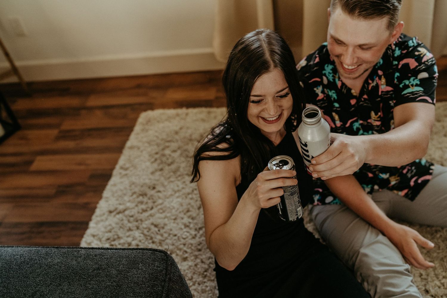Couple sharing a playful moment with a pet on a cozy living room couch.