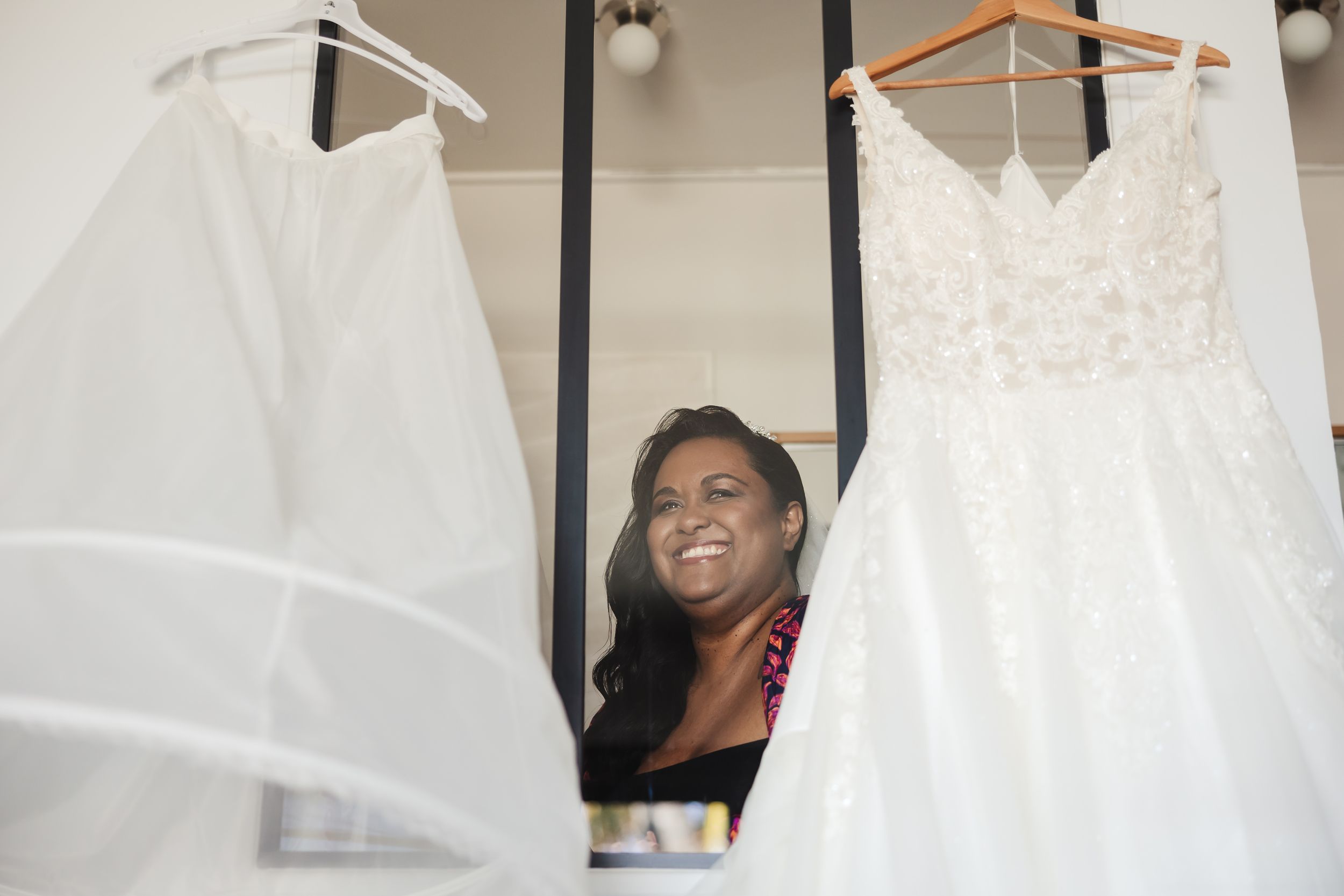 White wedding dresses displayed on hangers in a bridal boutique.
