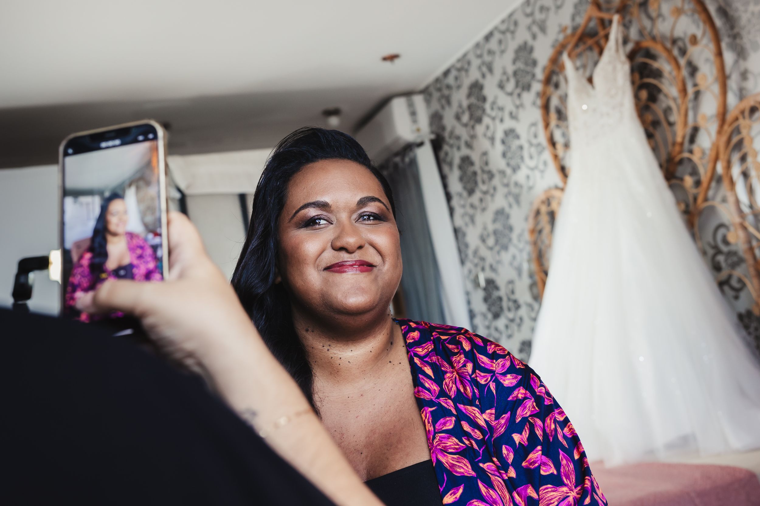 Wedding dress preparations with white gowns hanging in a bridal suite.