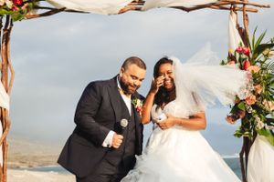 A beach wedding ceremony with floral decorations and ocean backdrop.