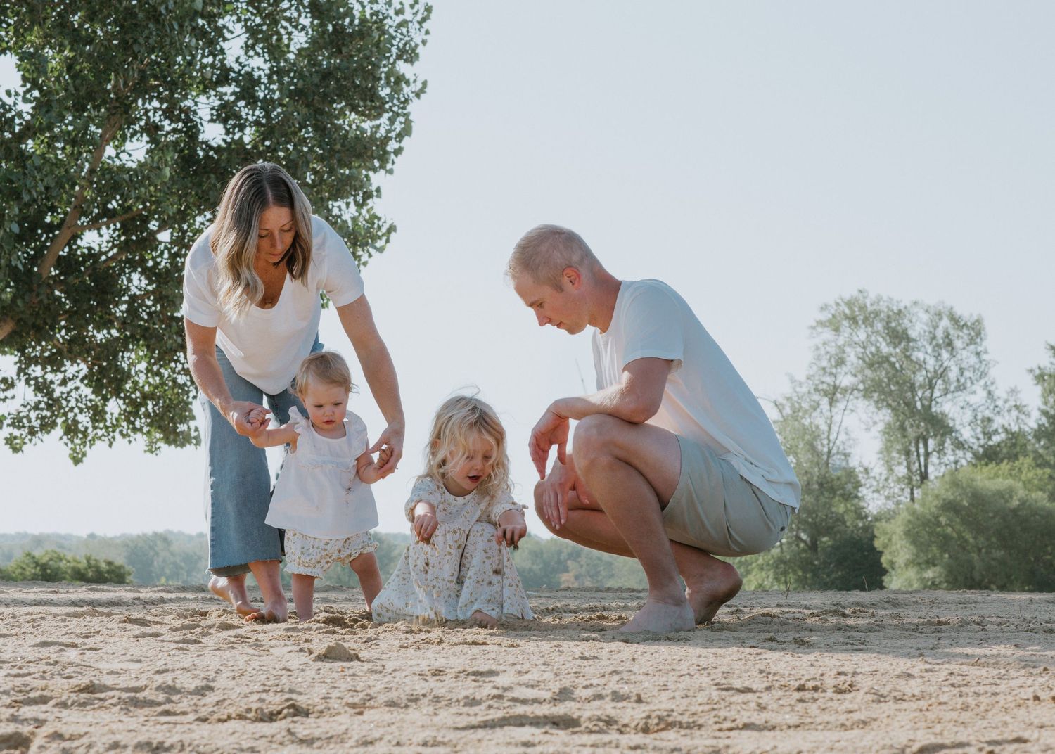 Family members exploring and interacting with each other on a sunny beach.