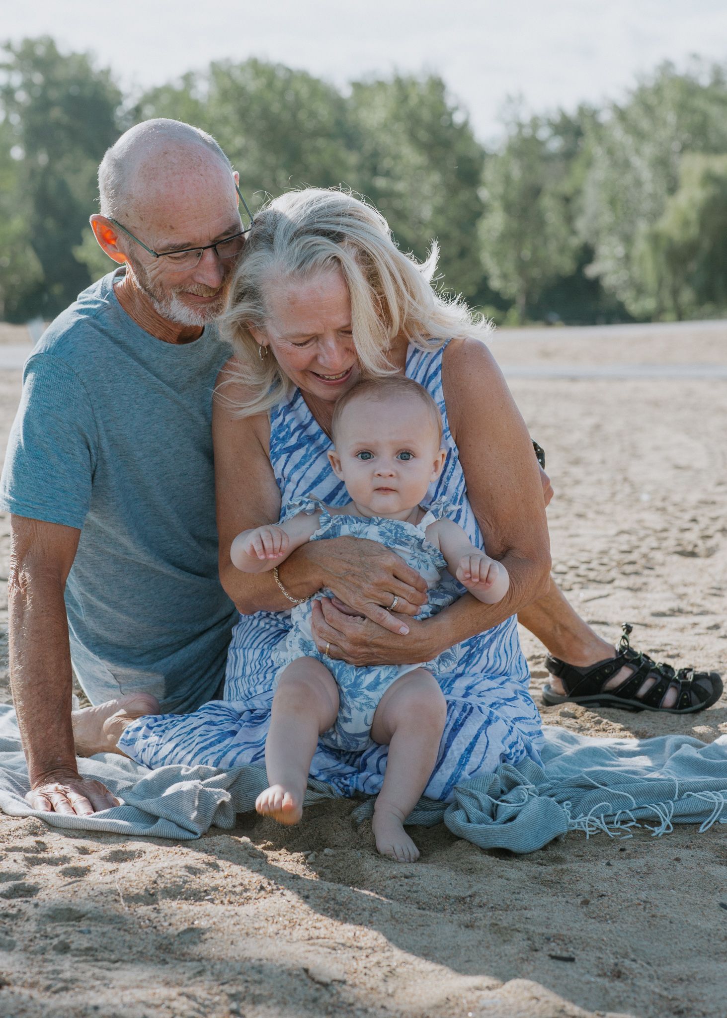 Sweet moments shared between grandparents and baby on a sunny beach.