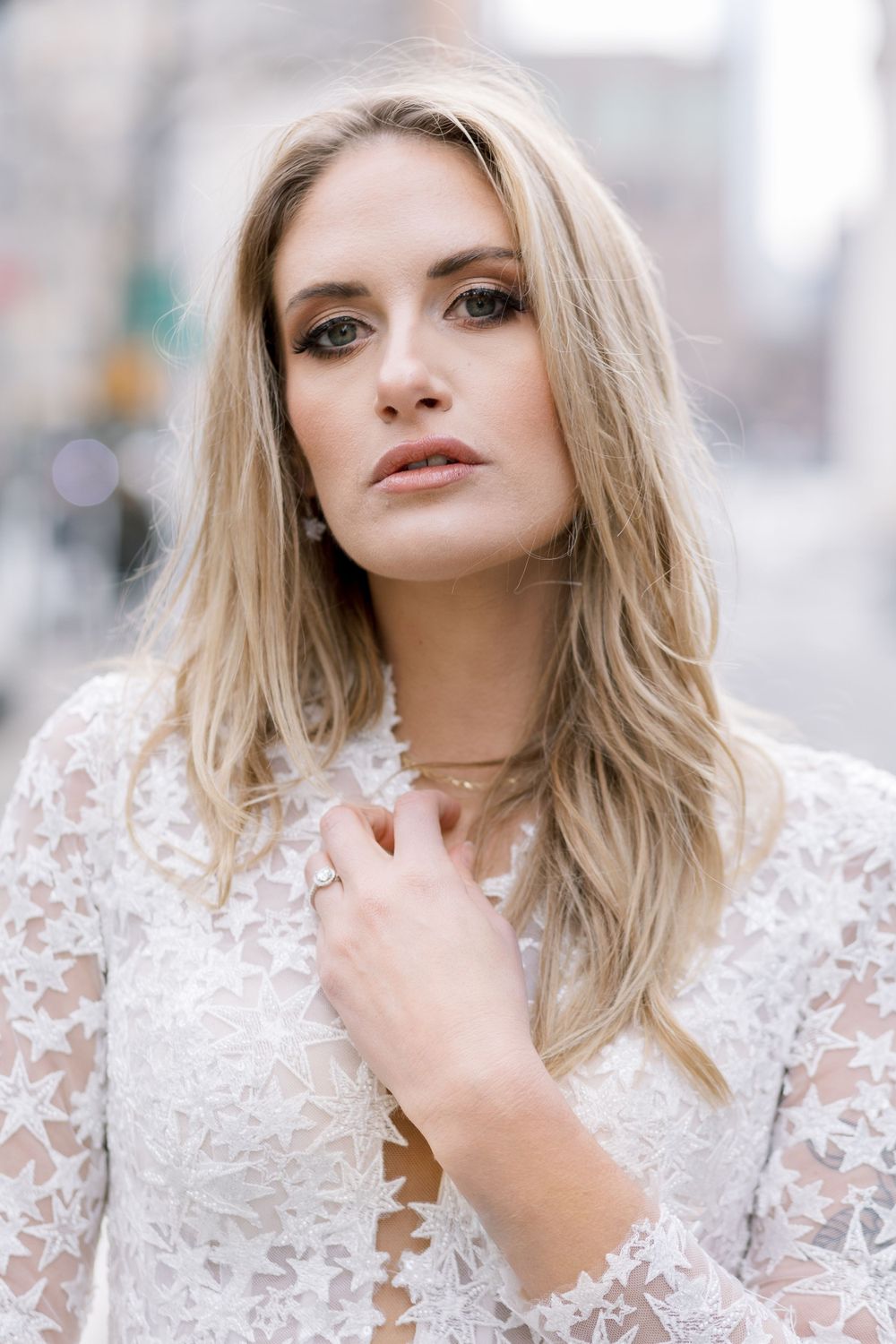 Close up beauty portrait in soft focus showing lace neckline detail and delicate makeup.