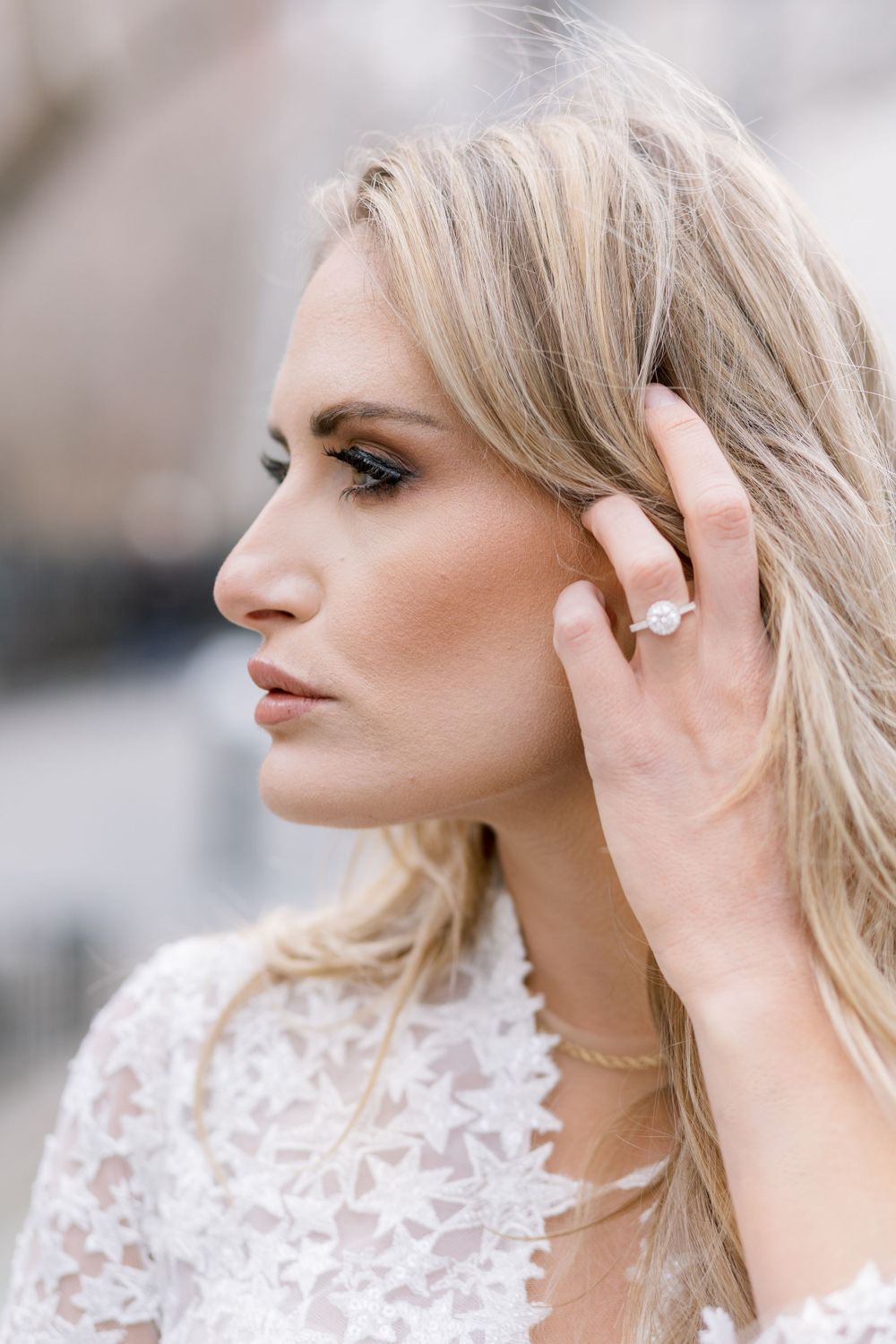 Close-up profile shot showing bridal jewelry and delicate lace details.