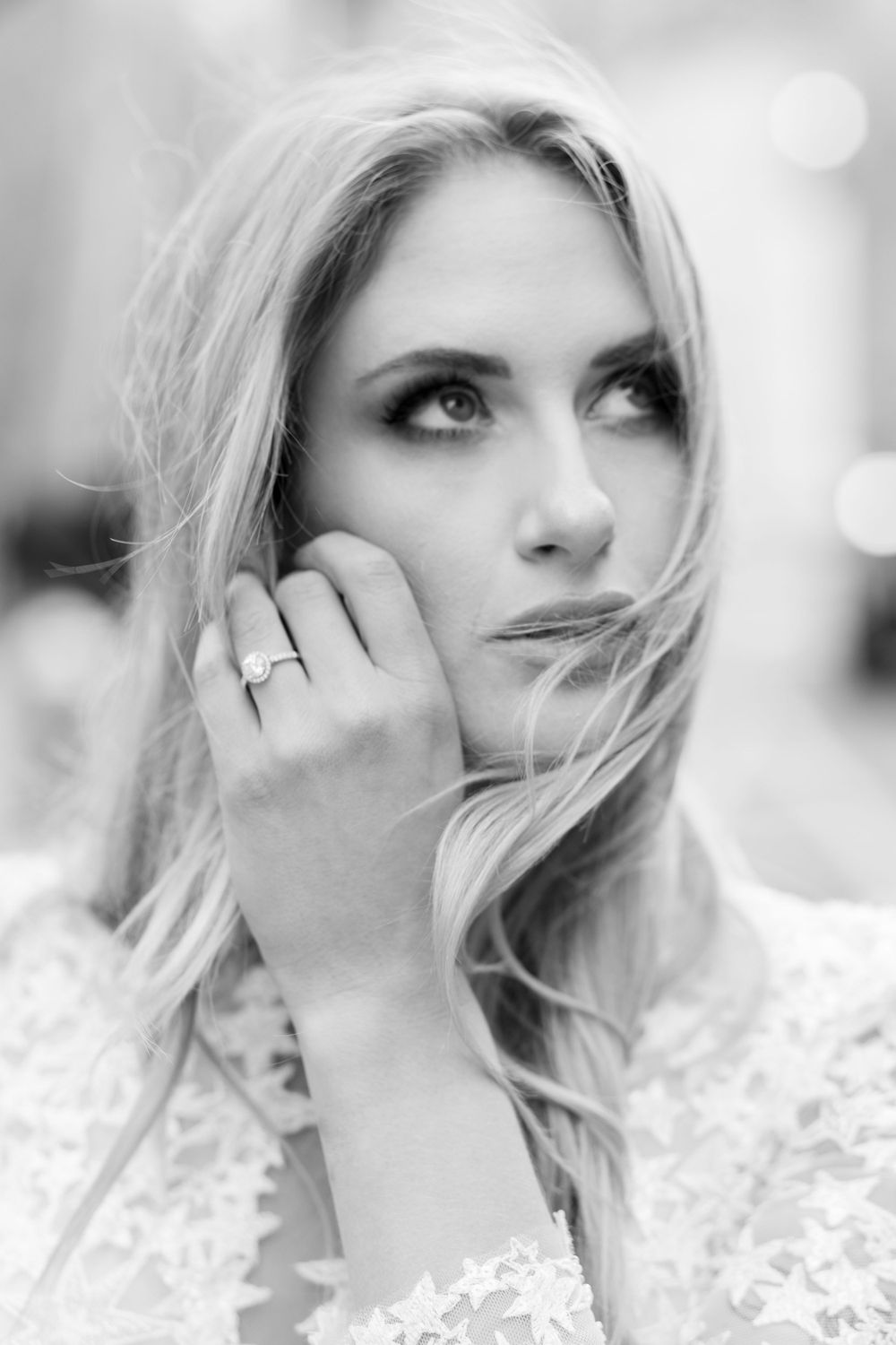 Dreamy black and white closeup portrait showing diamond ring and lace dress detail.