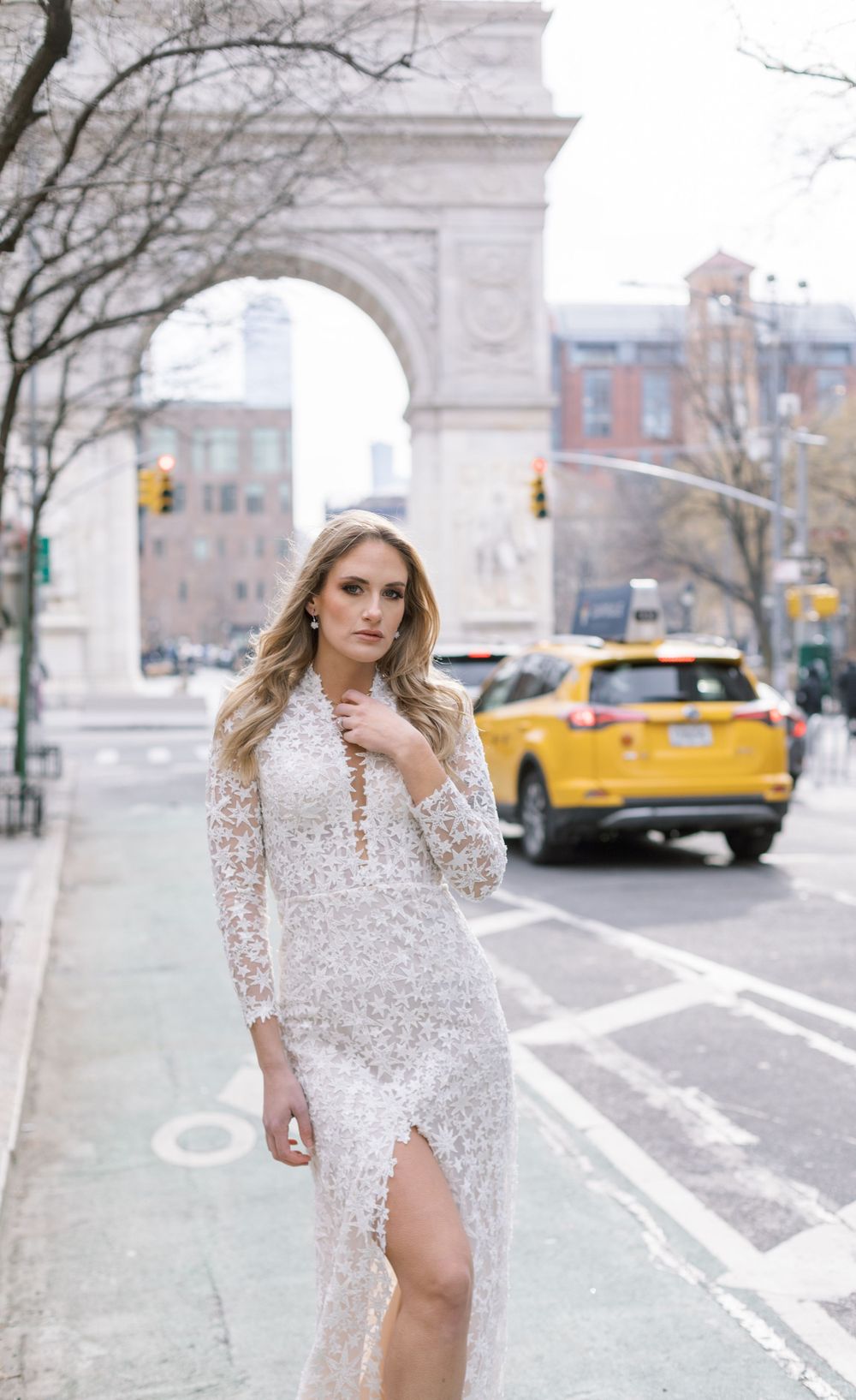 Street style bridal photo featuring lace gown with leg slit near Washington Square Park.