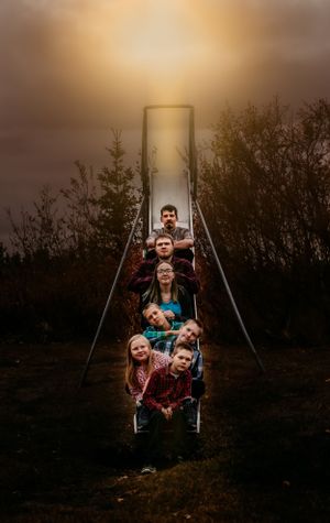 A creative portrait on a metal slide structure at sunset with a dreamy golden glow.