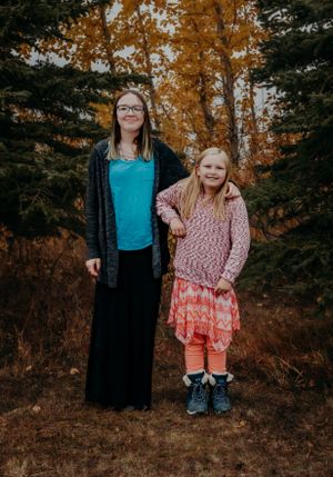 An autumn portrait featuring evergreen trees and golden fall foliage in the background.