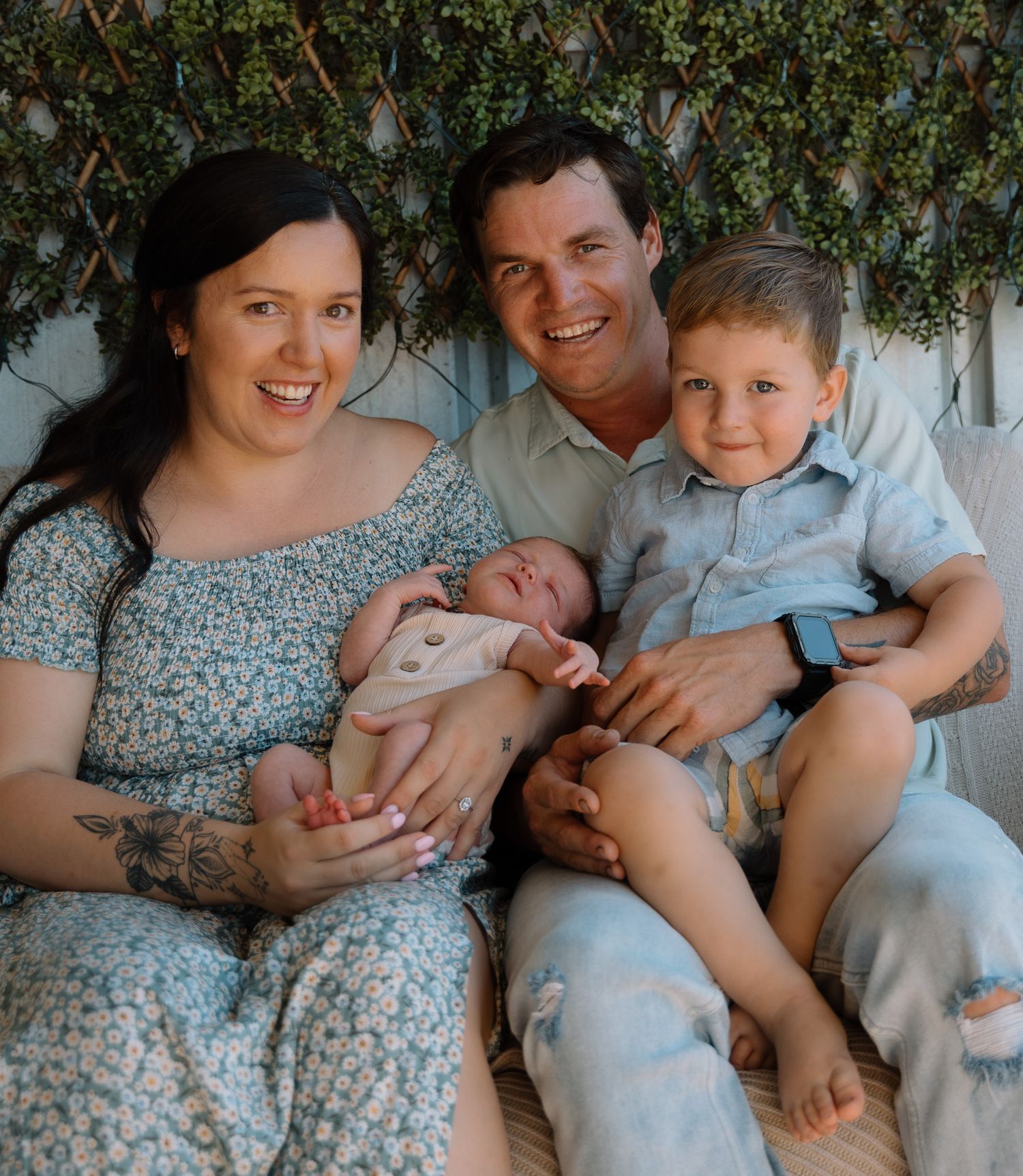 Family lifestyle photoshoot showing tender moments on floral patterned couch.