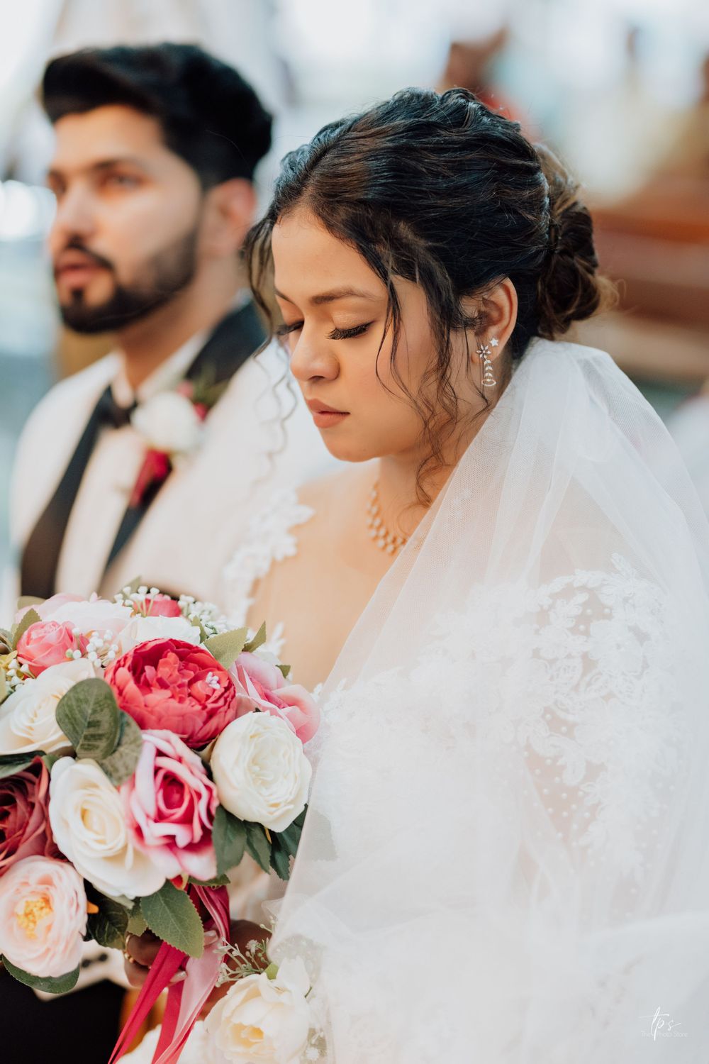 Wedding ceremony details with white veil and pink rose bouquet.