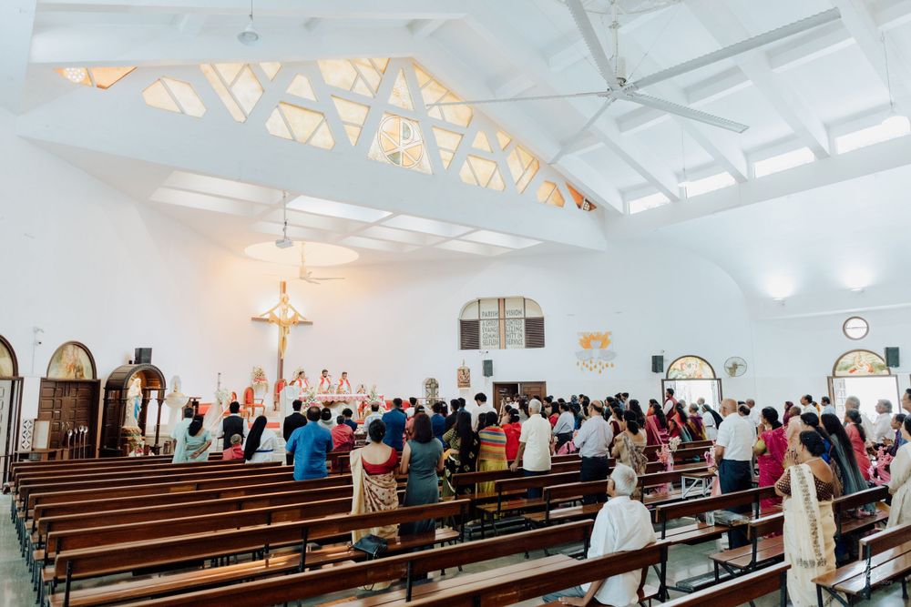Panoramic view of bright church interior with wooden pews and vaulted ceiling.