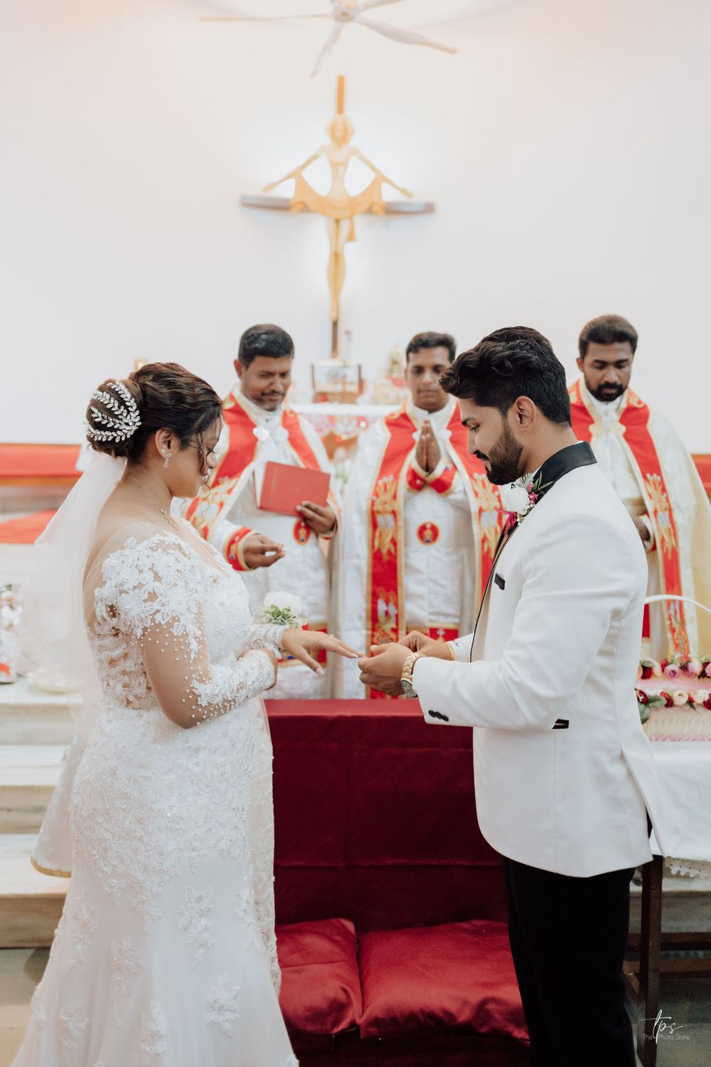 Traditional church wedding ceremony with red altar decorations.