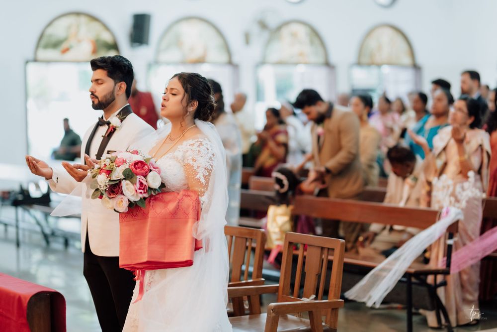 Wedding ceremony in a church with wooden pews filled with guests.