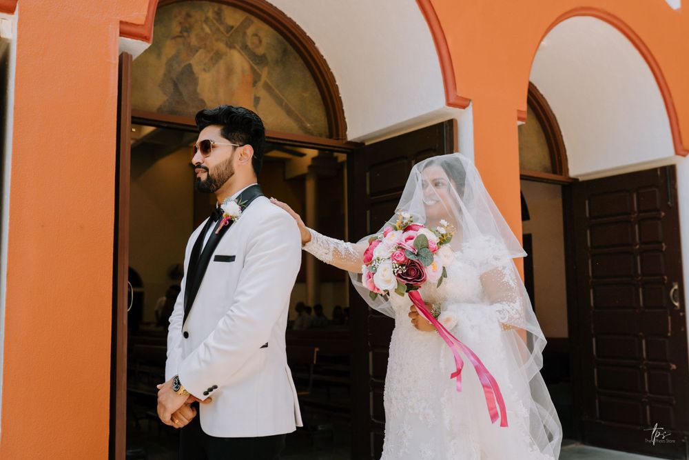 Elegant wedding portraits against vibrant orange wall with architectural details.