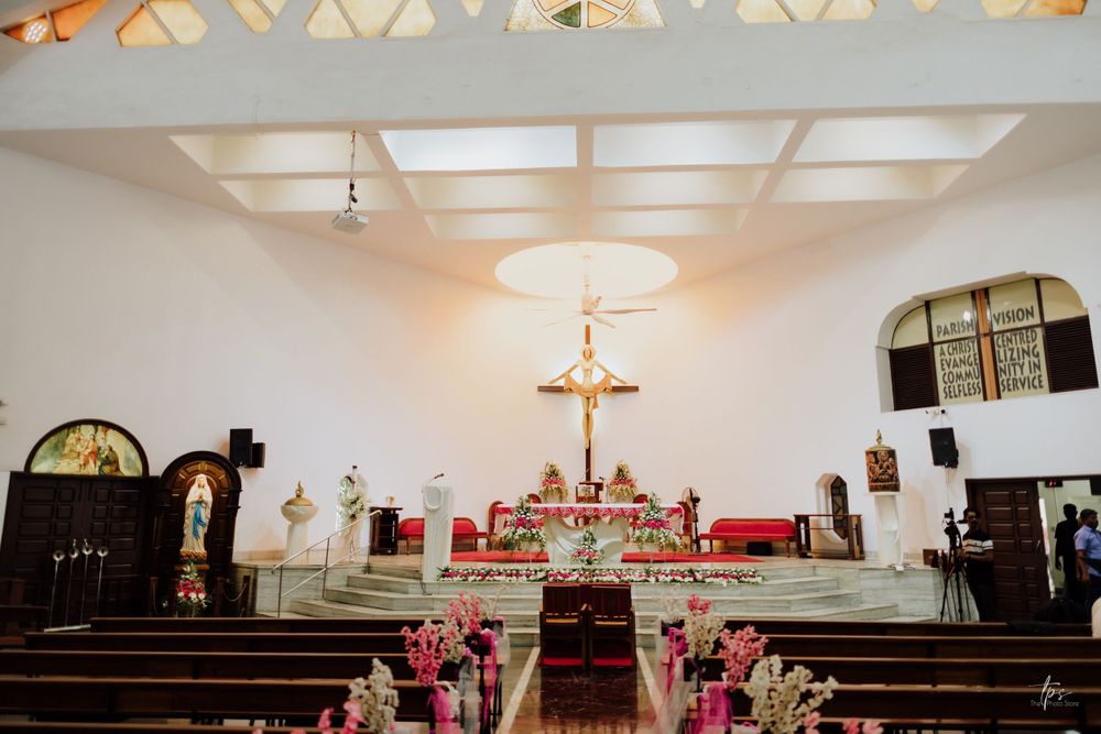 Modern church interior decorated with floral arrangements and skylight for wedding ceremony.