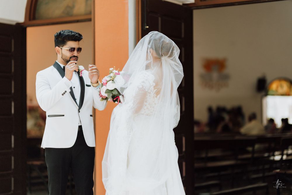 Wedding couple shares intimate moment in church interior with orange walls.