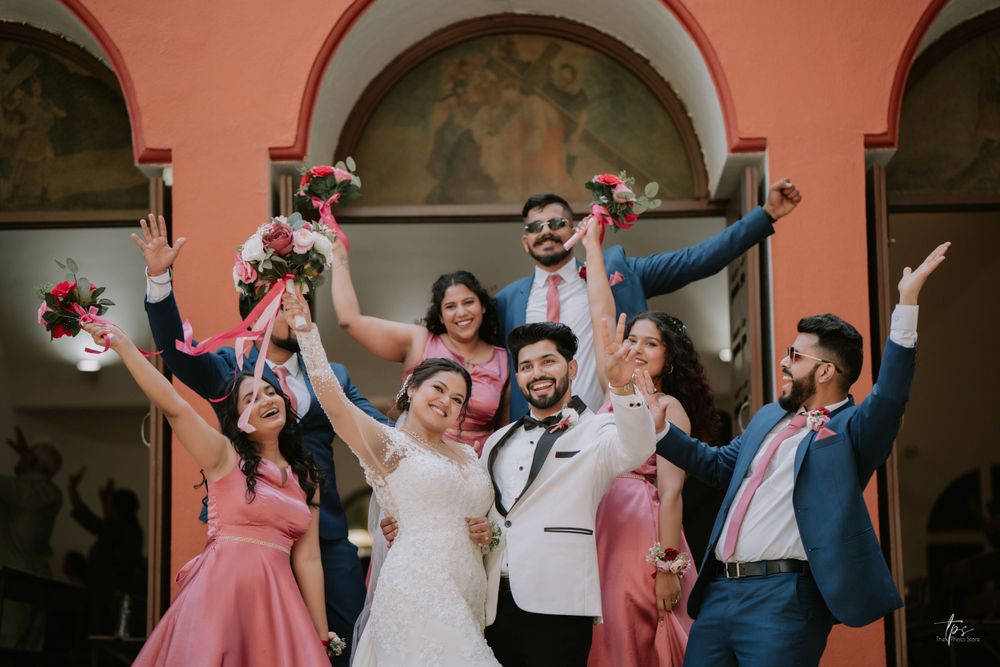 Bridal party dances and celebrates under coral archways during wedding reception.