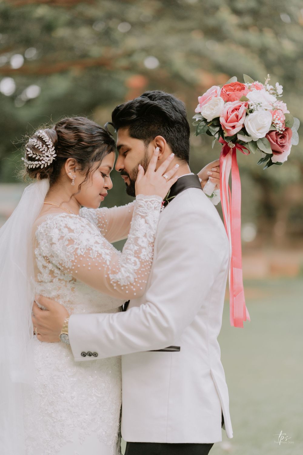 Intimate wedding couple sharing romantic moments with pink floral bouquet in outdoor setting.