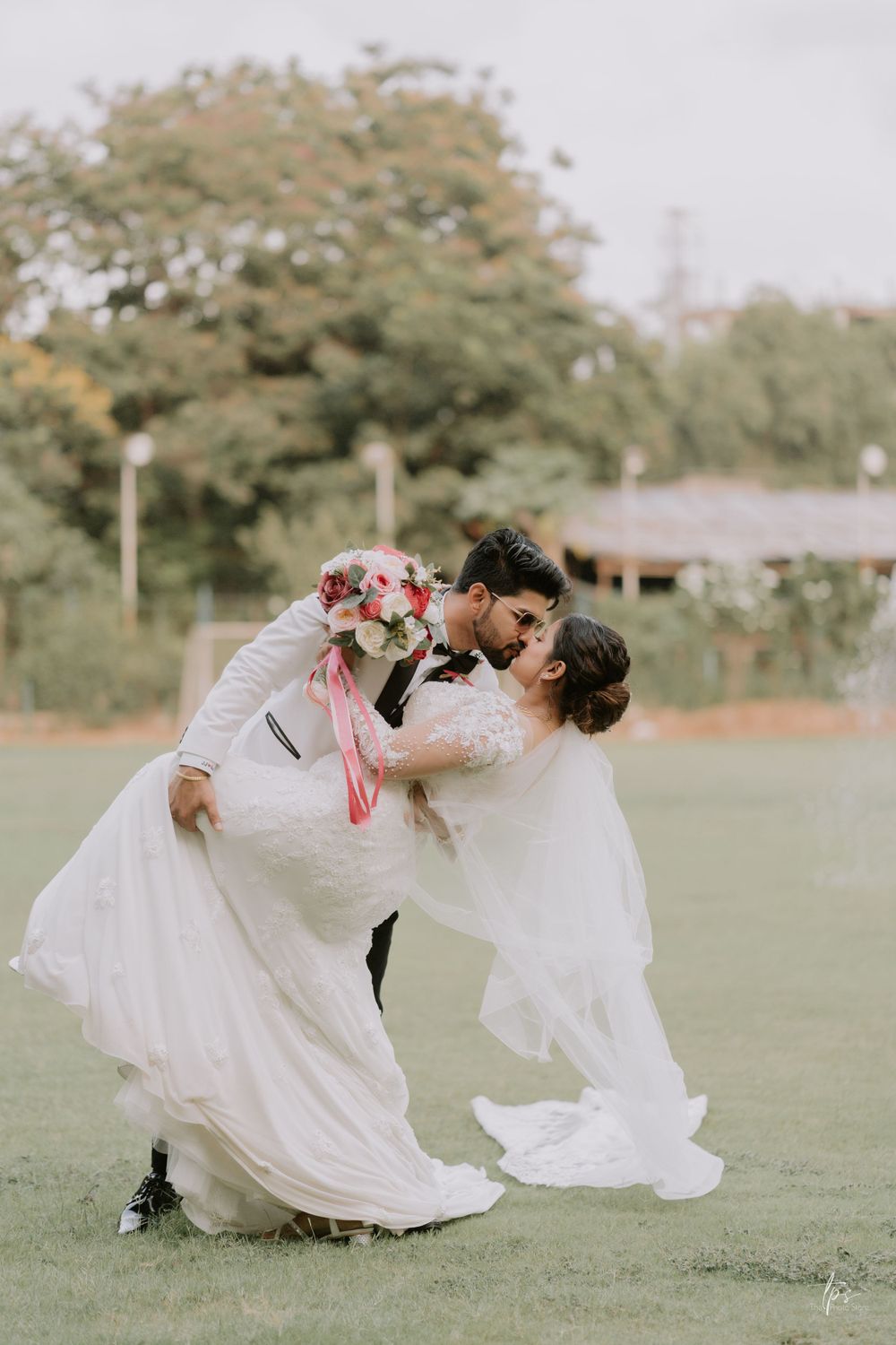 Romantic wedding dance dip sequence captured in outdoor garden setting.