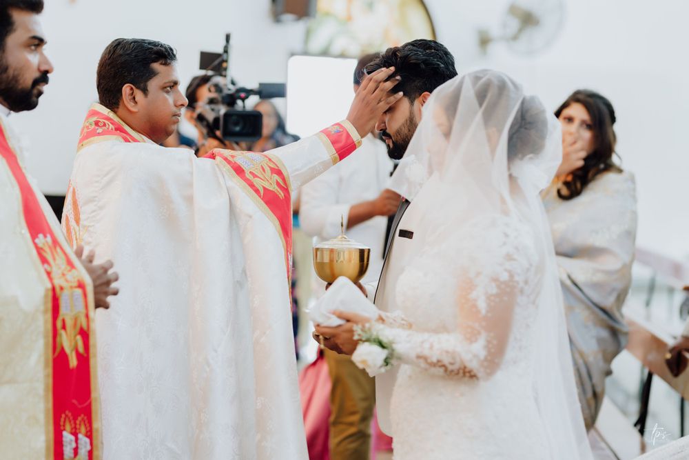 Wedding party members in white attire during indoor ceremony.